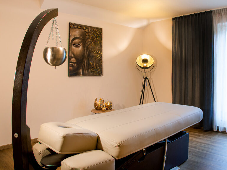 Auf dem Bild ist ein SPA-Raum zu sehen in dessen Mitte eine Liege steht